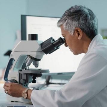 Scientist looking through microscope