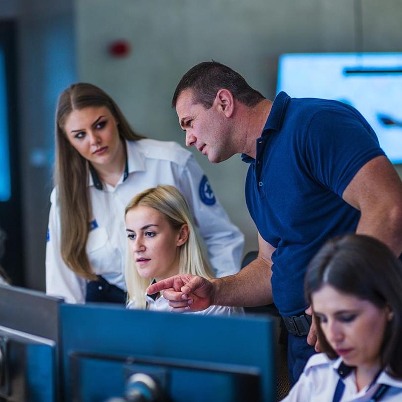 Team of police officers looking at computer monitors