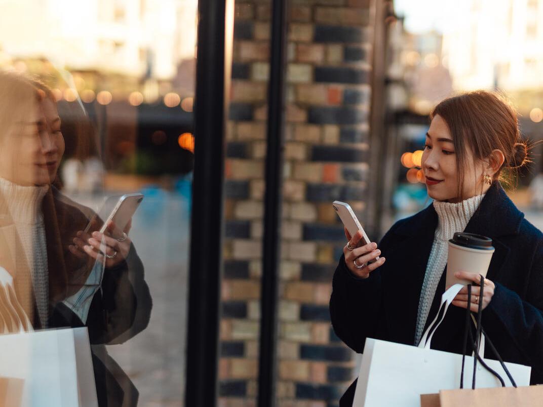 Woman looking at phone while shopping