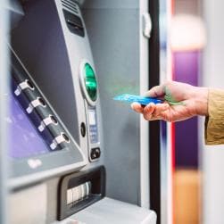 Female hand inserting card into ATM